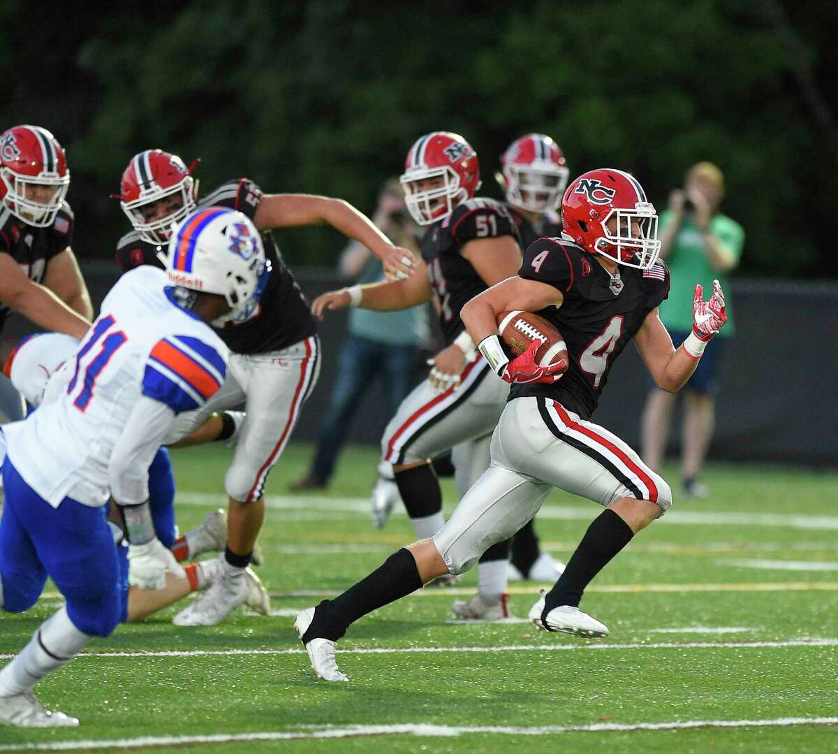 New Canaan’s Drew Guida (4) breaks away from the pack as the Rams defeated Danbury 42-6 in a FCIAC football game at Dunning Field on Friday, Sept. 14, 2018.
