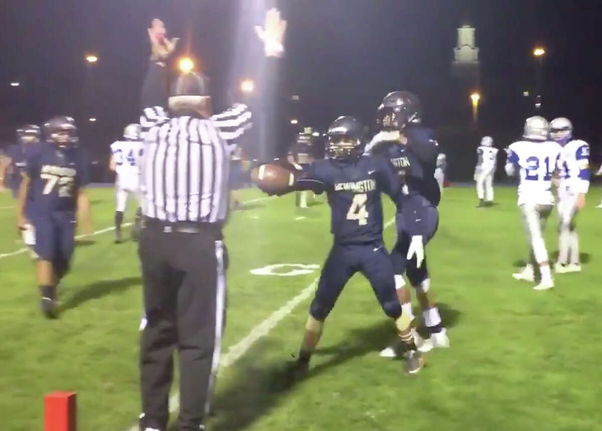 Newington receiver Izayah Ciarcia hands the ball to a side judge after scoring a touchdown at home last season (Screenshot)