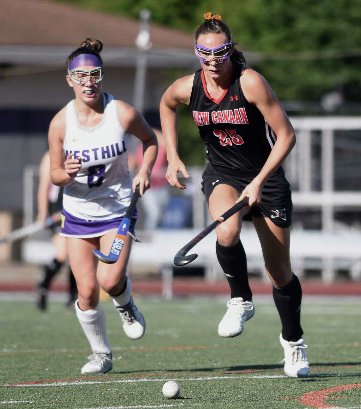 New Canaan's Polly Parsons-Hills (25) gets to the ball with Westhill's Hannah Burton (8) in pursuit during a field hockey game at Westhill High School in Stamford on Thursday, Sept. 19, 2019.