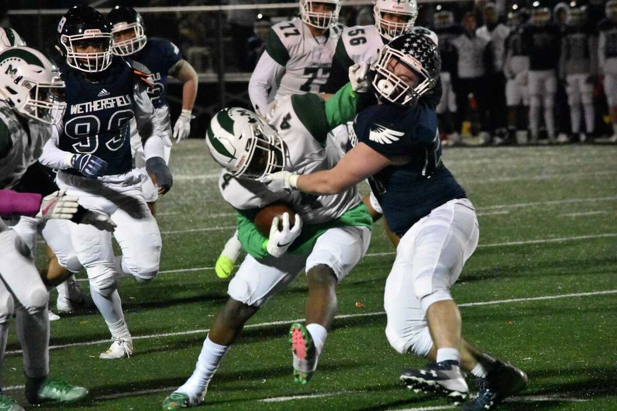 Maloney’s James Tarver breaks a tackle in the football game between Maloney and Wethersfield at Wethersfield high on Friday, Nov. 8, 2019. (Pete Paguaga, Hearst Connecticut Media)