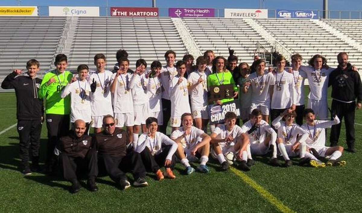 Stonington’s boys soccer team poses with its championship trophy after defeating Ellington, 1-0, in the Class M final, Saturday, Nov. 23, 219 at Dillon Stadium (Photo Will Aldam)