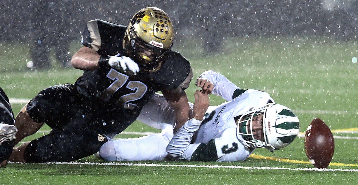 Ben Corniello of Daniel Hand (left) and Maloney quarterback Angel Arce (right) look toward a fumble in the Class L semifinal football game in Madison on December 9, 2019.