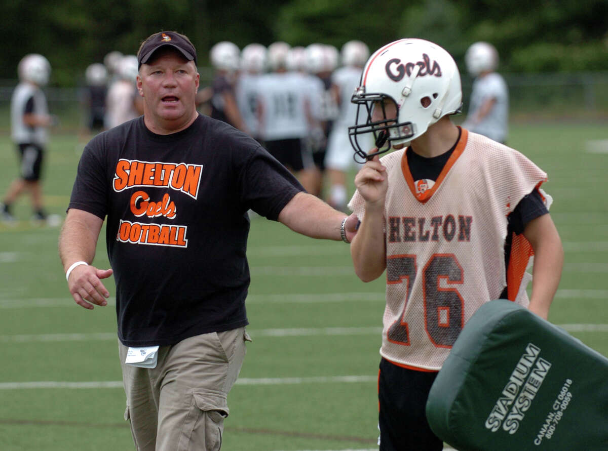 Football head coach Jeff Roy, left, gives instructions to C.J.(Charles) Mojcik during tackle drills at Shelton High School on Tuesday August 24, 2010.
