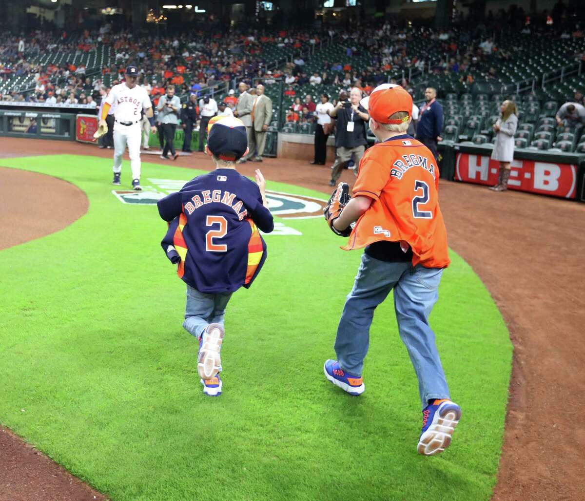Brady Columbus, right, and his brother Bryant run to Houston Astros third baseman Alex Bregman before Brady threw out the first pitch before the start of an MLB baseball game at Minute Maid Park on Tuesday, April 19, 2022 in Houston.