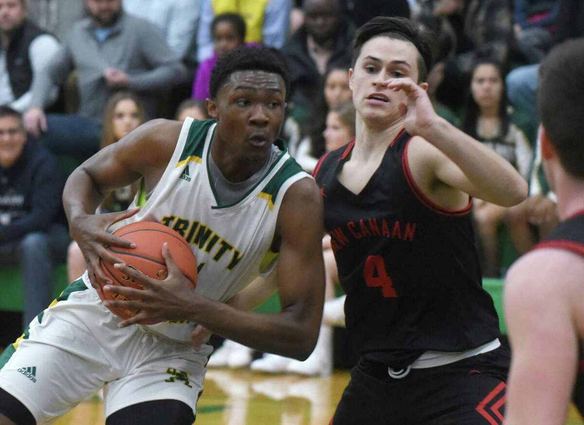 Trinity Catholic's Rahsen Fisher drives against New Canaan's Brandon Sechan (4) during a boys basketball game at Trinity Catholic High School in Stamford on Friday, Jan. 3, 2020.