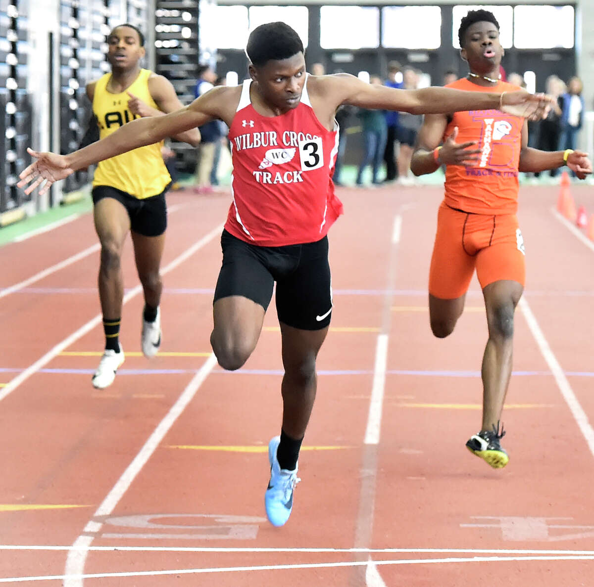 New Haven Connecticut - February 22, 2020: Caleb Owen of Wilbur Cross H.S. wins the boys 300-meter dash finals, center, crossing the finish line against third-place finisher Kymali Hay of Bloomfield H.S., right, and fourth-place finisher Rayshon Jacobs of Jonathan Law H.S, left. Jason Lorent of Shelton H.S. finished in second place. during the CIAC State Open Indoor Track Championship Saturday at the Floyd Little Athletic Center in New Haven.