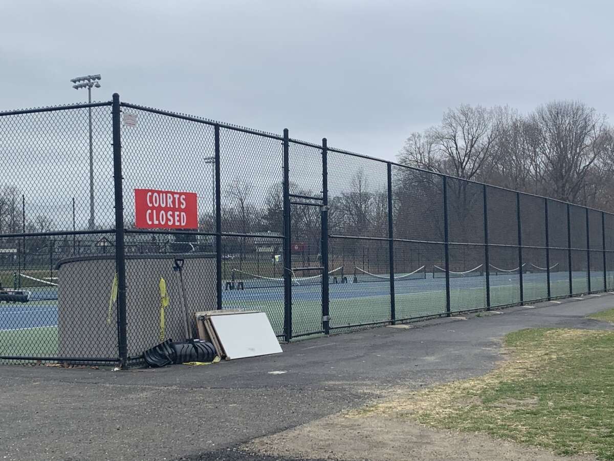 The tennis courts at New Canaan High School, which were filled around 2:30 p.m. Friday, March 27, are empty and locked behind a “Courts Closed” sign around the same time Monday, March 30. The CIAC officially canceled its spring sports season on Tuesday.