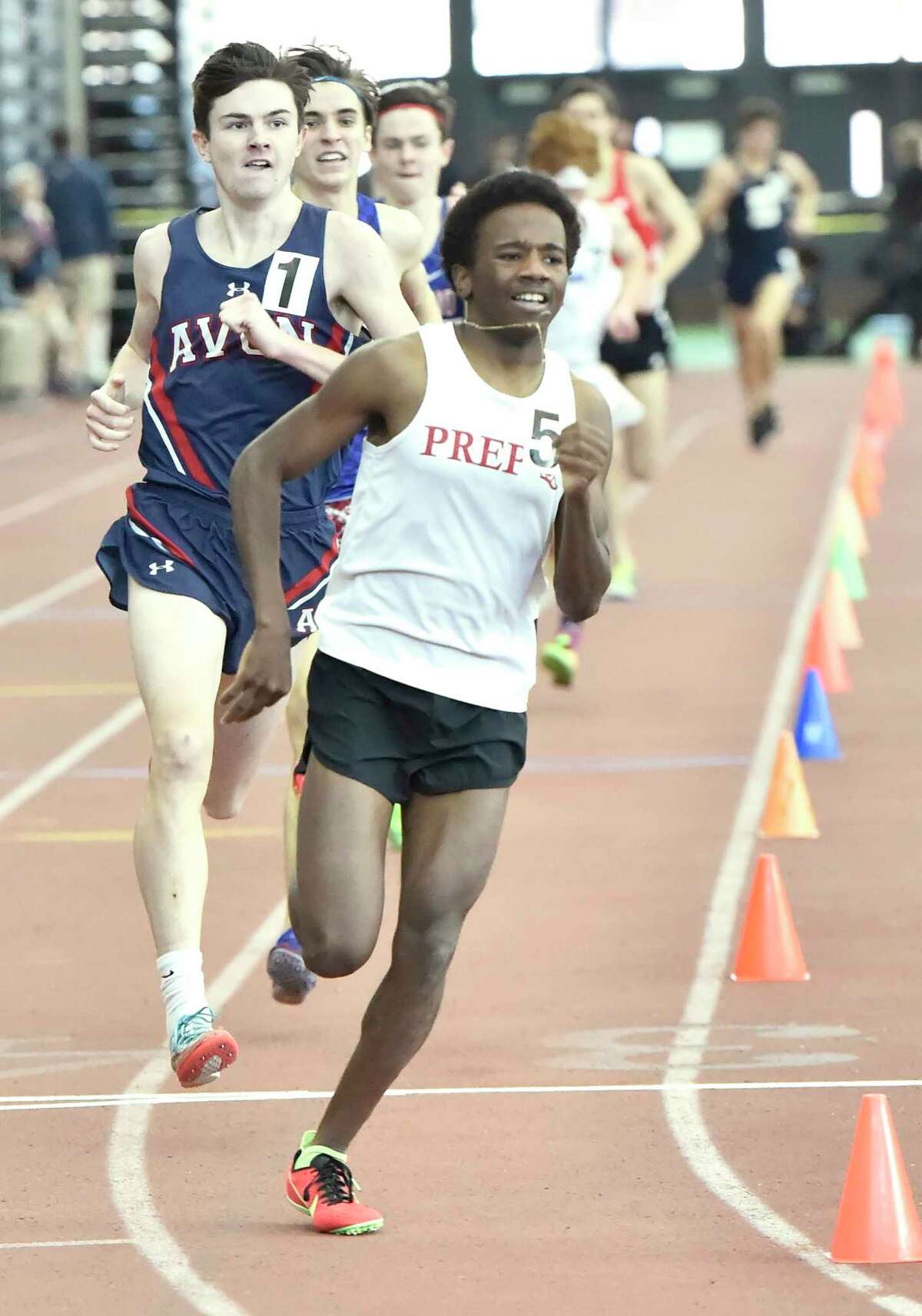 New Haven Connecticut - February 22, 2020: Third-place finisher Azaan Dawson of Fairfield Prep leads the pack early against eventual winner Jack Martin of Avon H.S., left, and third-place finisher Alec Sauter of Tolland H.S. during boys 1600-meter run at the CIAC State Open Indoor Track Championship Saturday at the Floyd Little Athletic Center in New Haven.