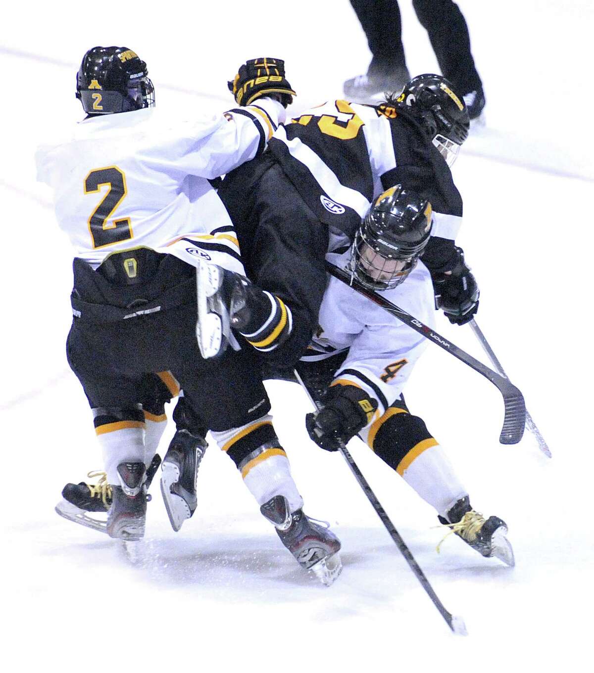 (Peter Casolino-New Haven Register) Amity Regional’s Ryan Hauser, left, and Scott Saffran put the hit on Hand’s Benjamin Solin during the 3rd period. 3/21/14