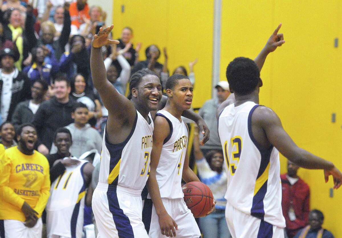 (Peter Casolino-New Haven Register) Career’s Jordan Lomar, left, Tyreek Perkins and Amos Ford, right, celebrate their win for the Class L boys basketball semifinals over Bristol Central.