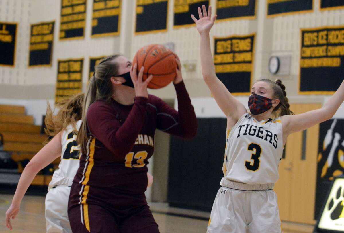 Sheehan’s Caitlyn Hunt (13) shoots while defended by Daniel Hand’s Hadley Houghton (3) during a girls basketball game on Friday, Feb. 26, 2021 in Wallingford, Conn.