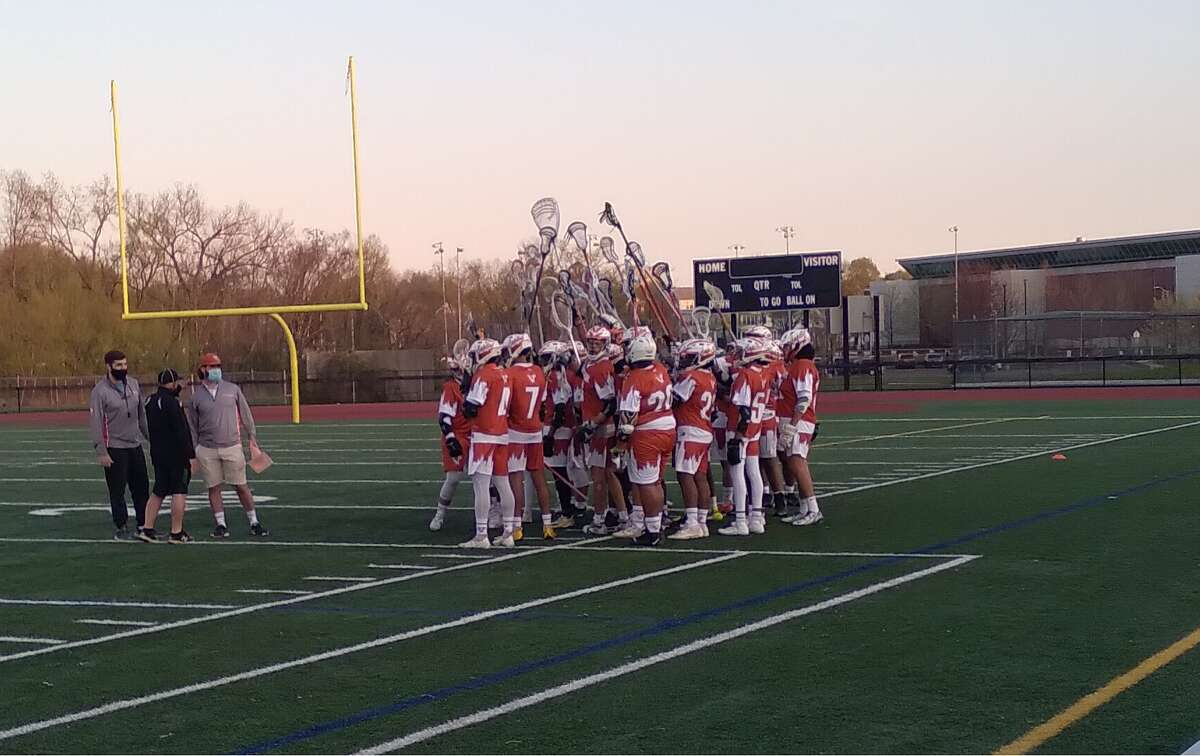 The Capital Prep/Classical boys lacrosse team huddles before playing Wilbur Cross at Bowen Field in New Haven, Conn., on April 20, 2021.