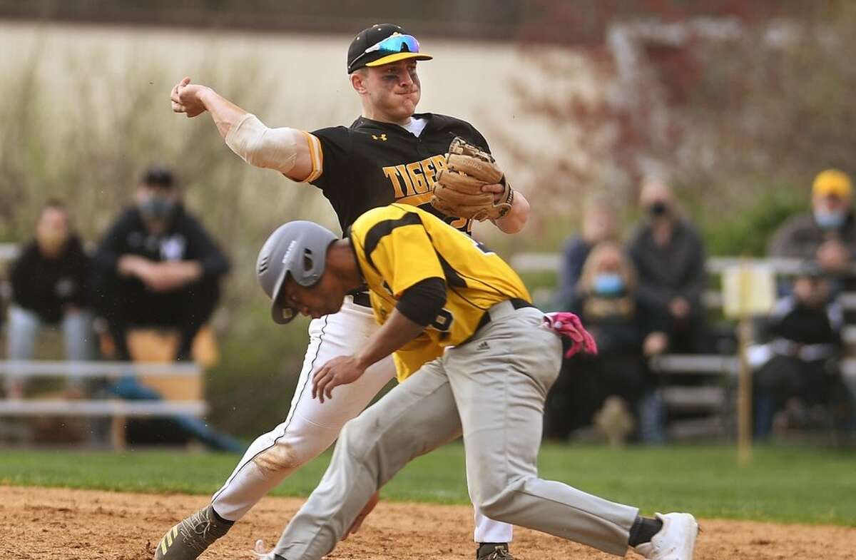 Hand third baseman Anthony DePino starts a double play as Amity’s Julian Stevens ducks beneath the throw during the 4th inning of their baseball game at Amity High School in Woodbridge, Conn. on Monday, April 19, 2021.