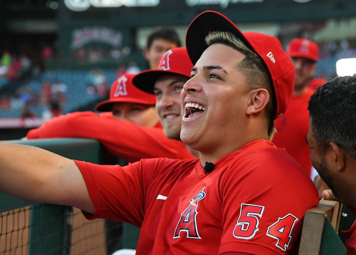 Relief pitcher Jose Suarez of the Los Angeles Angels laughs in the dugout during the game against the Houston Astros at Angel Stadium of Anaheim on September 21, 2021 in Anaheim, California.