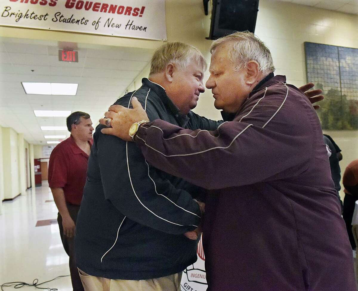 Pete Barbarito embraces Mike Marone, son of Horace Marone who served as head football coach at Wilbur Cross from 1957-1974, during a dedication ceremony naming the Barbarito/Marone Football Field in their honor Saturday morning.