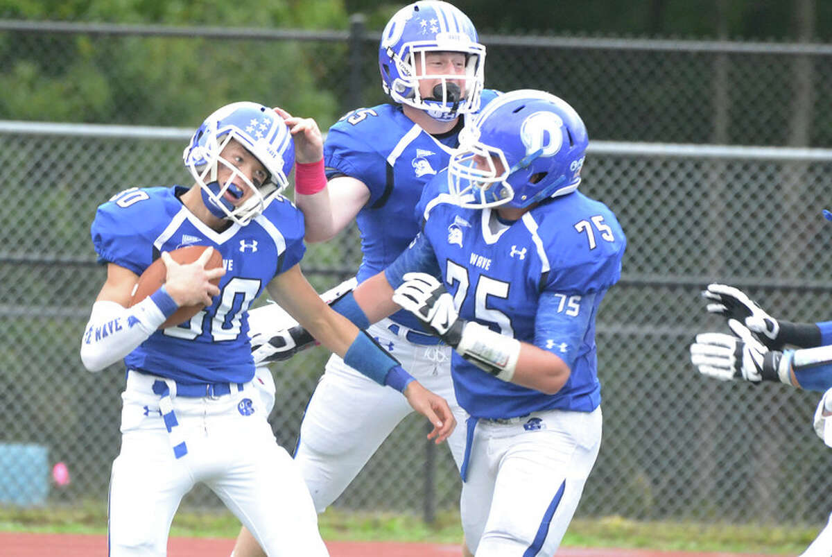 Darien’s Sam Bowtell (75) and Josh Stevenson (55) celebrate with Todd Herget (left) after a touchdown catch during the Blue Wave’s comeback 21-17 victory over St. Joseph (Photo Peter Paguaga)