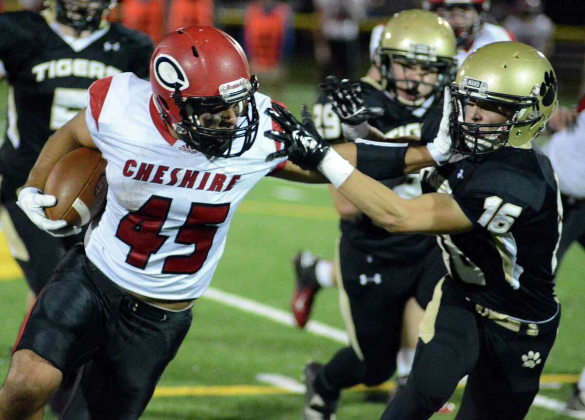 Cheshire running back Andrew Yamin stiff-arms a Hand defender on his way to 294 rushing yards Friday night in Madison. Photo by Dave Phillips