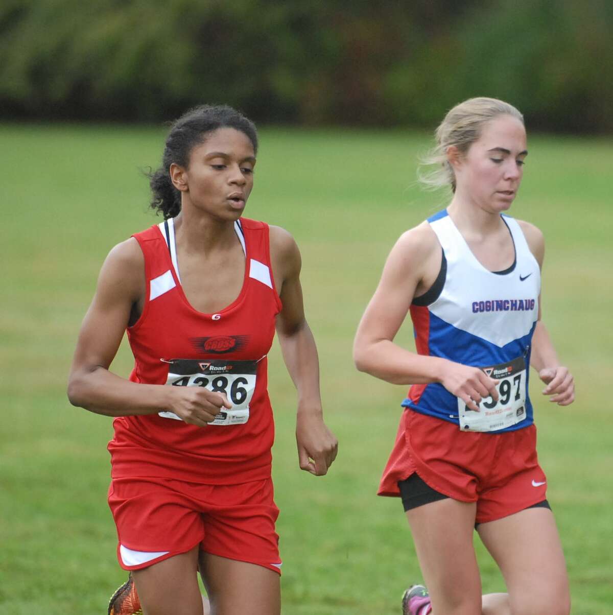 Danae Rivers of Wilbur Cross runs next to Samantha Drop of Coginchaug during Saturday’s seeded varsity girls’ race at Wickham Park in Manchester. Photo by Mary Albl