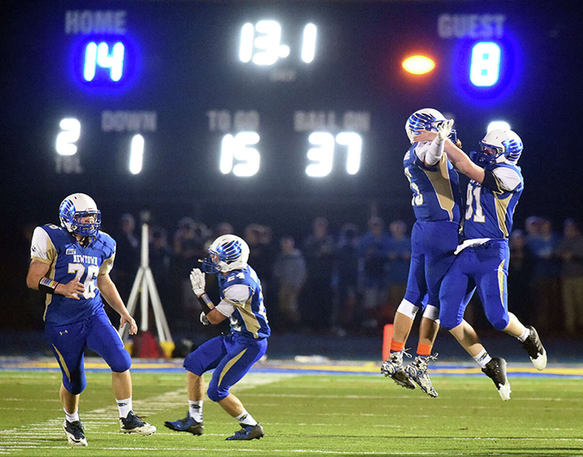Newtown football players celebrate their win over Ansonia Oct. 17, 2014. Their 14-8 victory ended Ansonia’s streak of 48 consecutive games (Photo by Peter Hvizdak – New Haven Register)