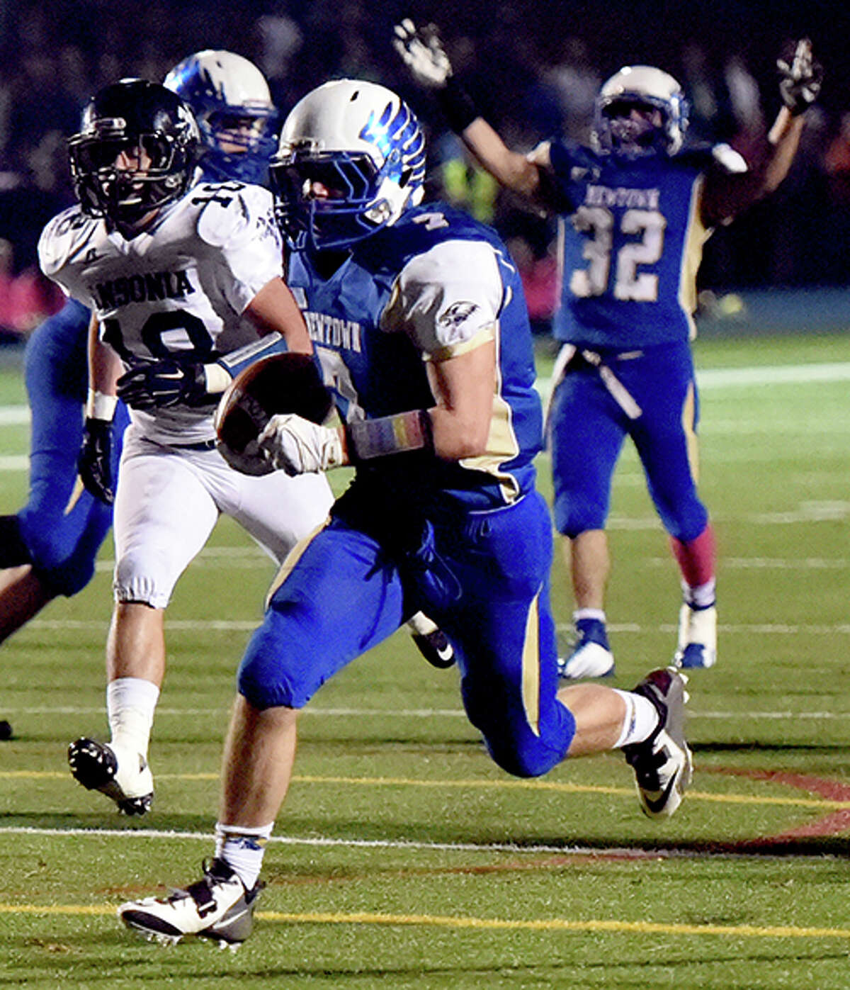 Jared Pearson runs for a first-quarter 18-yard touchdown for Newtown during its 14-8 victory over Ansonia. Newtown never trailed and ended the Chargers’ 48-game win streak (Photo Peter Hvizdak)