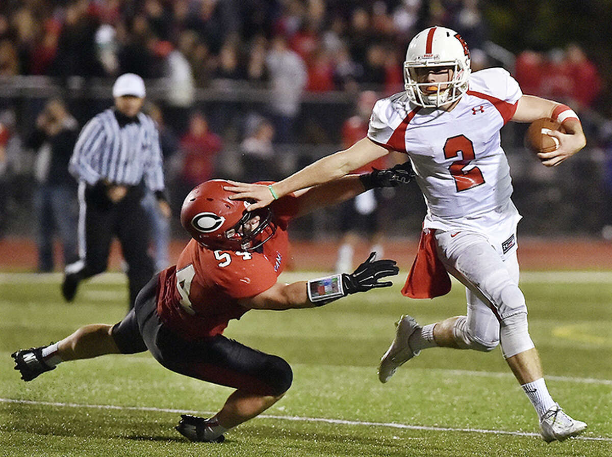 Fairfield Prep’s Colton Smith stiff arms Cheshire’s Tyler D’errico Friday night, October 24, 2014. Fairfield defeated Cheshire, 51-28. (Catherine Avalone – New Haven Register)