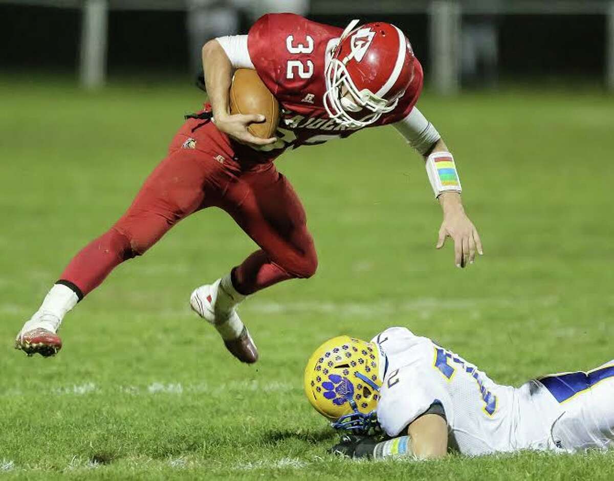 Derby running back Ricky Bartone jumps over Seymour’s C.J. Falcioni during their NVL contest Friday. Derby won 62-44. John Vanacore/For the Register