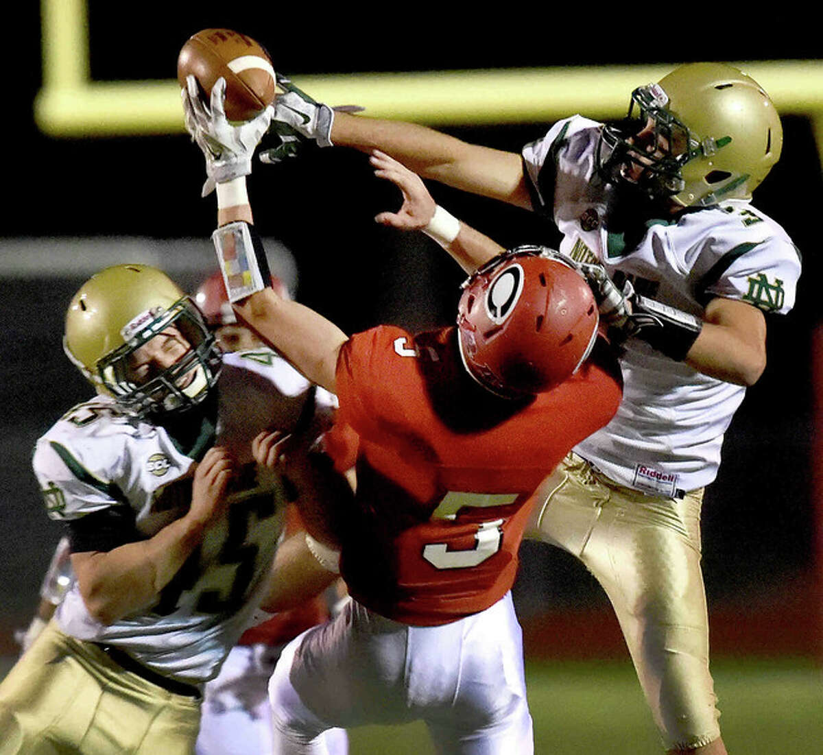 Tim Jambor, left, and teammate Nico Ragaini, right, of Notre Dame H.S. break up a pass play intended for Colin Thorne of Cheshire High School during first quarter football action at Cheshire H.S. Friday evening, October 31, 2014. (Photo by Peter Hvizdak)