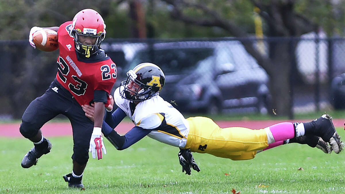 Wilbur Cross tailback Stevie Swinson tries to slip past and Amity defender in a game last month. (Photo by Catherine Avalone – Register)