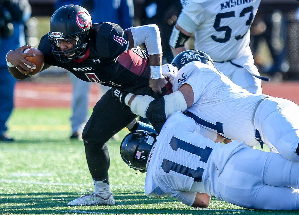 VROL’s Chris Jean-Pierre tries to break a tackle by Ansonia’s Vitold Gul (11) in the Class S-Large state final (Photo John Vanacore)