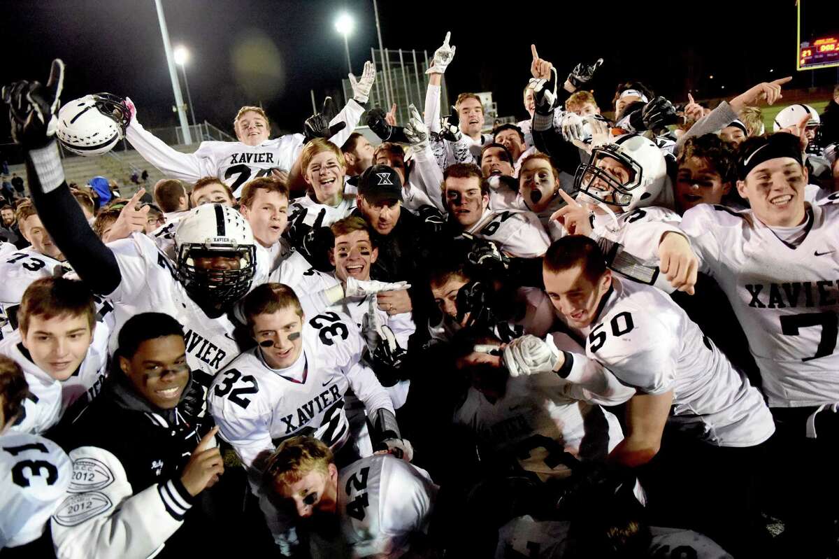 (Peter Hvizdak – New Haven Register) Fourth-seeded Xavier celebrates after defeating second-seeded and previously unbeaten Southern Connecticut Conference rival Shelton, 28-27 in overtime in the CIAC Class LL-Small finals Saturday.