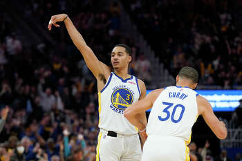 Golden State Warriors' Jordan Poole (3) reacts to San Francisco 49ers'  Deebo Samuel on the sideline after hitting a shot in the second half of an  NBA basketball game against the Memphis