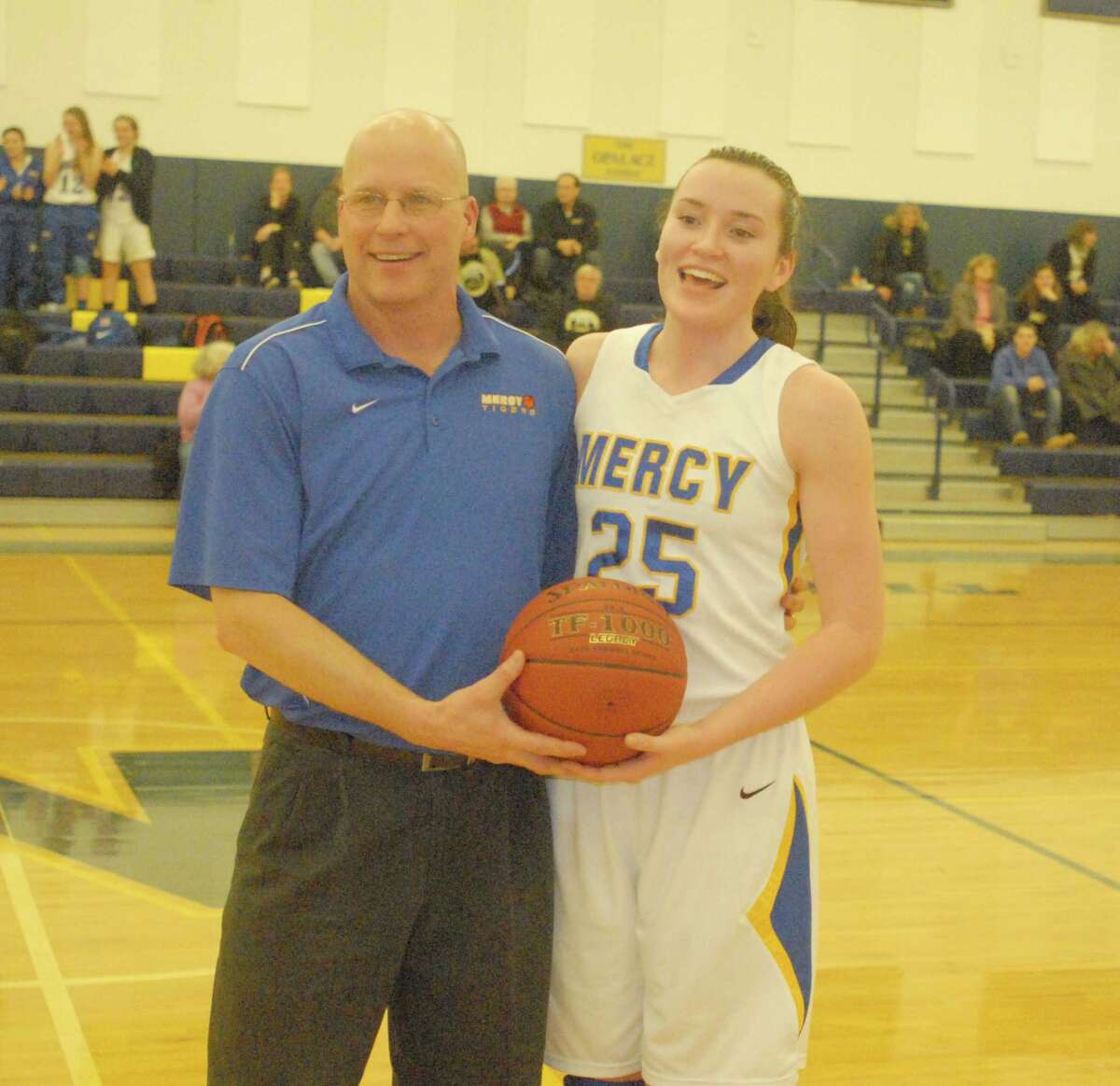 Mercy senior Maura Fitzpatrick, pictured with Tigers coach Tim Kohs, scored her 1,000th career point Thursday night in Mercy’s victory over Law. Photo: Jimmy Zanor