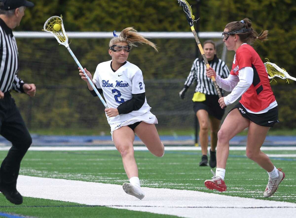 Darien's Chloe Humphrey (2) brings the ball up the field during the Wave's girls lacrosse game against New Canaan on Tuesday, April 19, 2022.