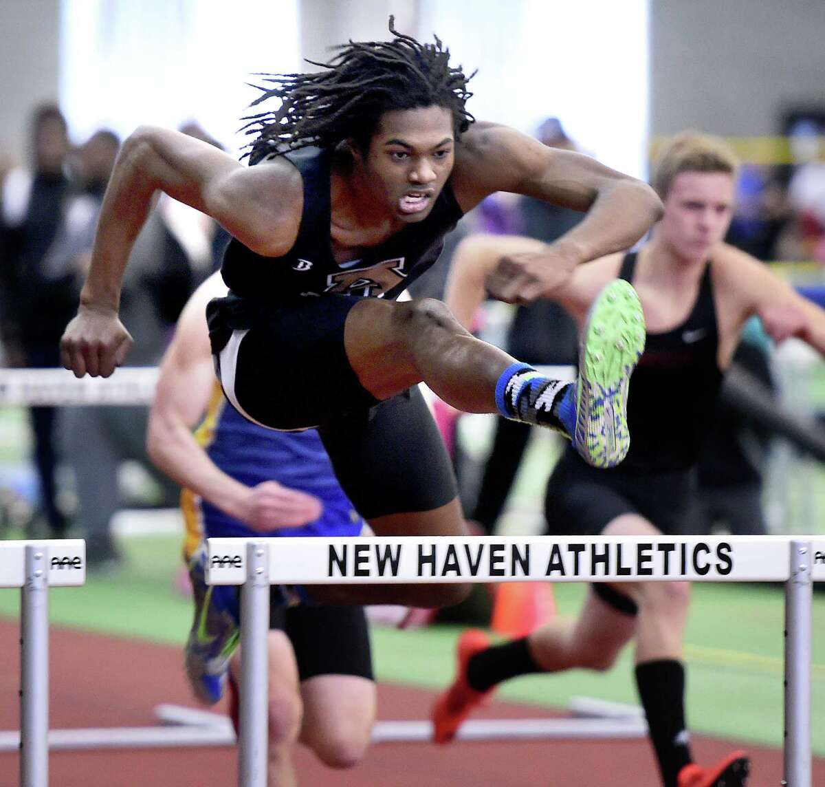 Aaron Rattley of Amity clears the last hurdle to place first in the 55 meter hurdles at the CIAC Class LL Indoor Track & Field Championship at the Floyd Little Athletic Center. Photo by Arnold Gold/New Haven Register agold@newhavenregister.com