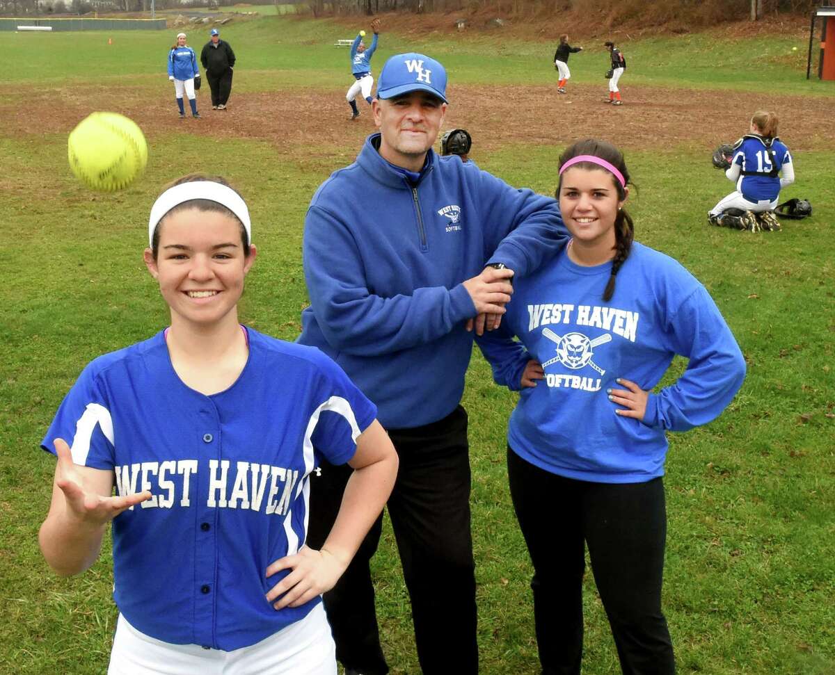 West Haven softball coach Joe Morrell flanked by his daughters, Jolie, a first baseman, left, and Jocey, an assistant coach.