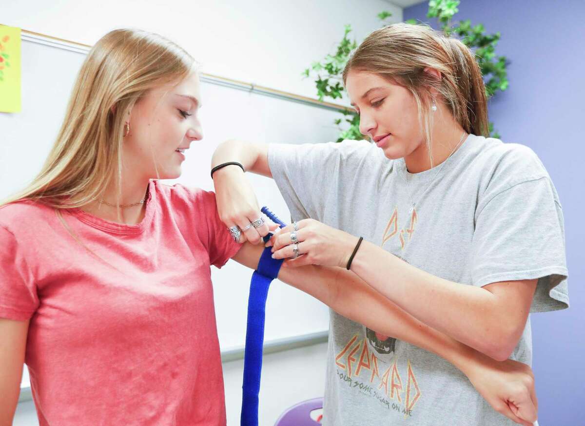 Kaitlyn Weightman, right, practices applying a tourniquet to Kaidence Kana as Montgomery High School students received hands-on training from HCA Houston Healthcare nurses and other staff as part of the Stop the Bleed Training, Wednesday, April 20, 2022, in Montgomery. The training is part of a national campaign focused on teaching community members how to render aid to victims of traumatic events like shootings, car accidents, burns and other emergencies.