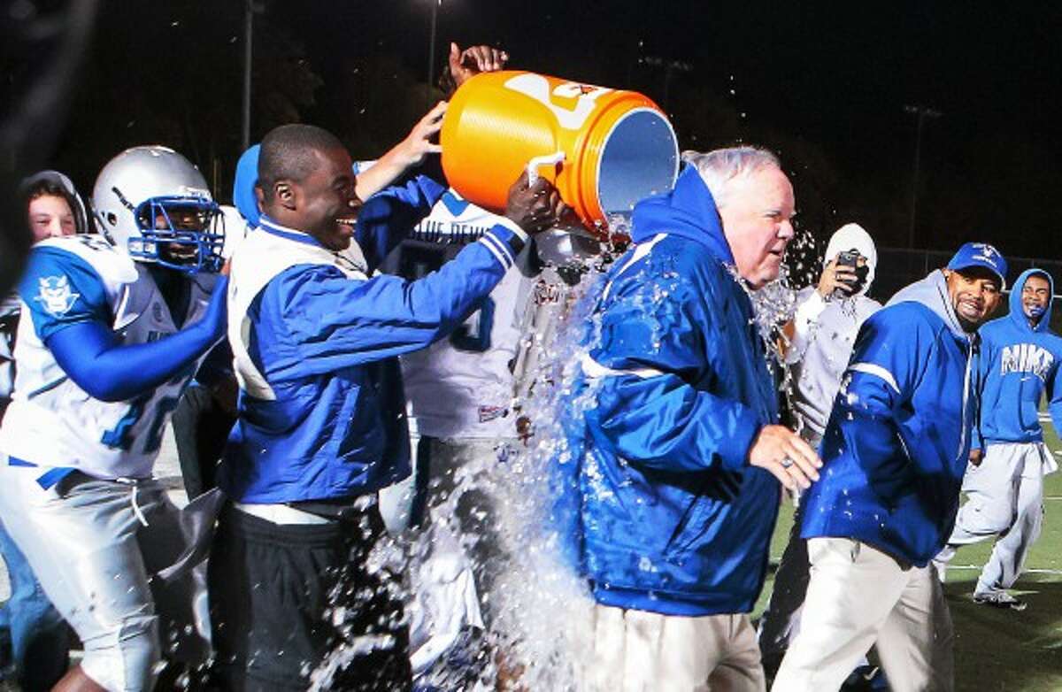 West Haven football coach Ed McCarthy gets an ice bath from his team’s players after defeating Hamden 49-7 in celebration of McCarthy’s 322 career win, setting the all-time record in 2013.