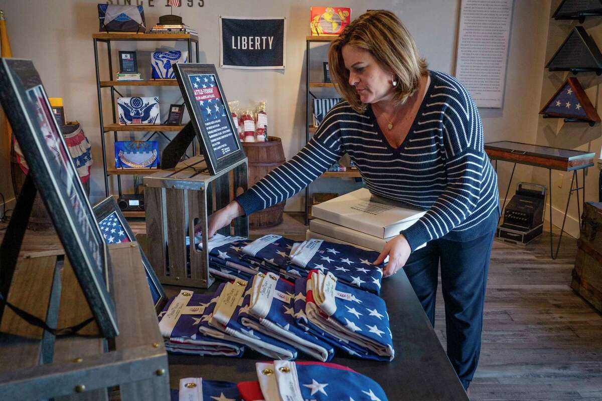 Maria Coffey, marketing manager at Gettysburg Flag Works, places American flags in a display at the business on on Wednesday, April 20, 2022, in East Greenbush, N.Y. (Paul Buckowski/Times Union)