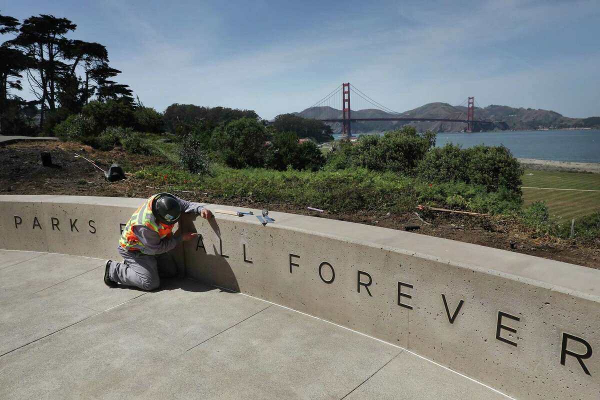 Luis Ortega works on lettering on a sign in preparation for the opening of Battery Bluff park during a tour of Battery Bluff park in the Presidio on Thursday, April 7, 2022 in San Francisco, Calif. Battery Bluff is a 6-acre park, which will open in April in the Presidio.