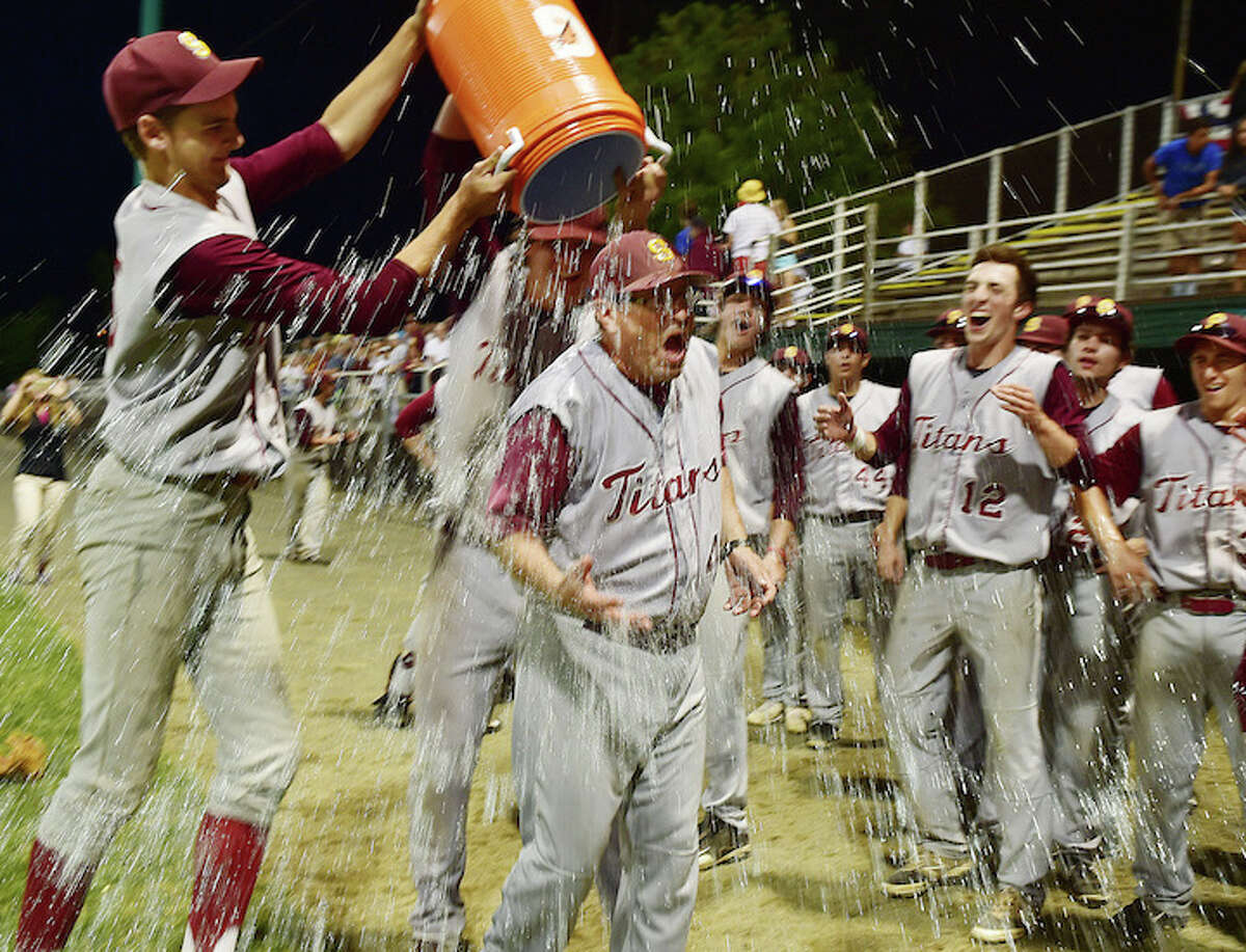 Sheehan’s Nolan Cloutier (5), left and Zach Hart (17), at right, douse their coach Matthew Altieri with a ice water after defeating the Montville Indians, 5-0, for the Class M state baseball championship, Friday, June 12, 2015, at Palmer Field in Middletown. (Catherine Avalone/New Haven Register)