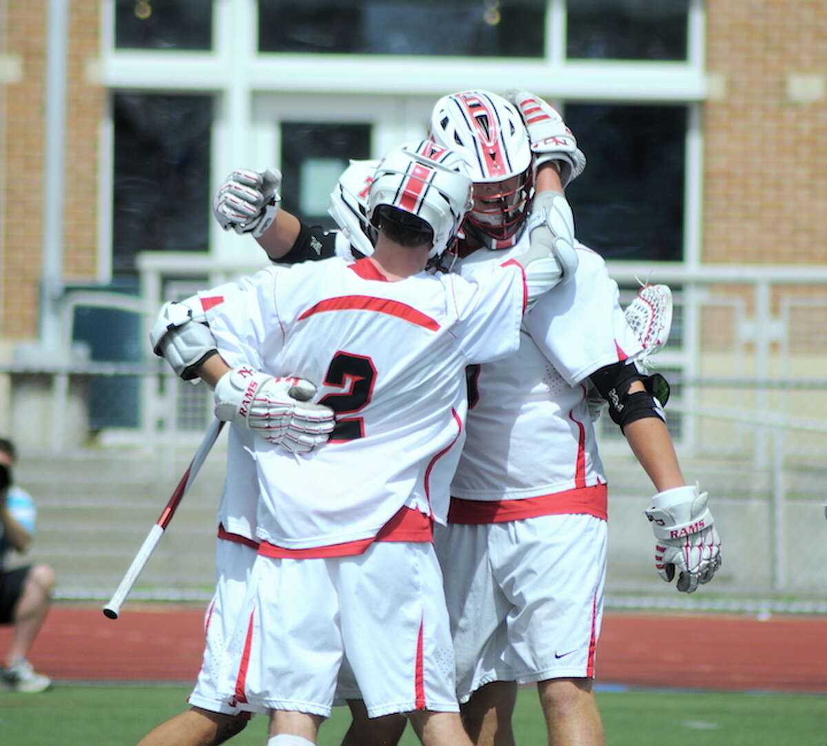 New Canaan’s players celebrate with Justin Meichner (2) after one of his goals vs. Hand during the Class M boys lacrosse championship (Photo Sean Meenaghan)