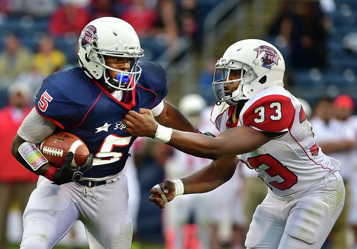 Constitution All-Star Jharron Wallace, of Glastonbury grabs Nutmeg All-Star Enyce Walker, of East Hartford in the CHSCA Super 100 Classic Football All-Star Football Game, Saturday afternoon, June 27, 2015, at Rentschler Field in East Hartford. Walker led Team Nutmeg to a 44-22 win and earned the offensive MVP. (Catherine Avalone/New Haven Register)