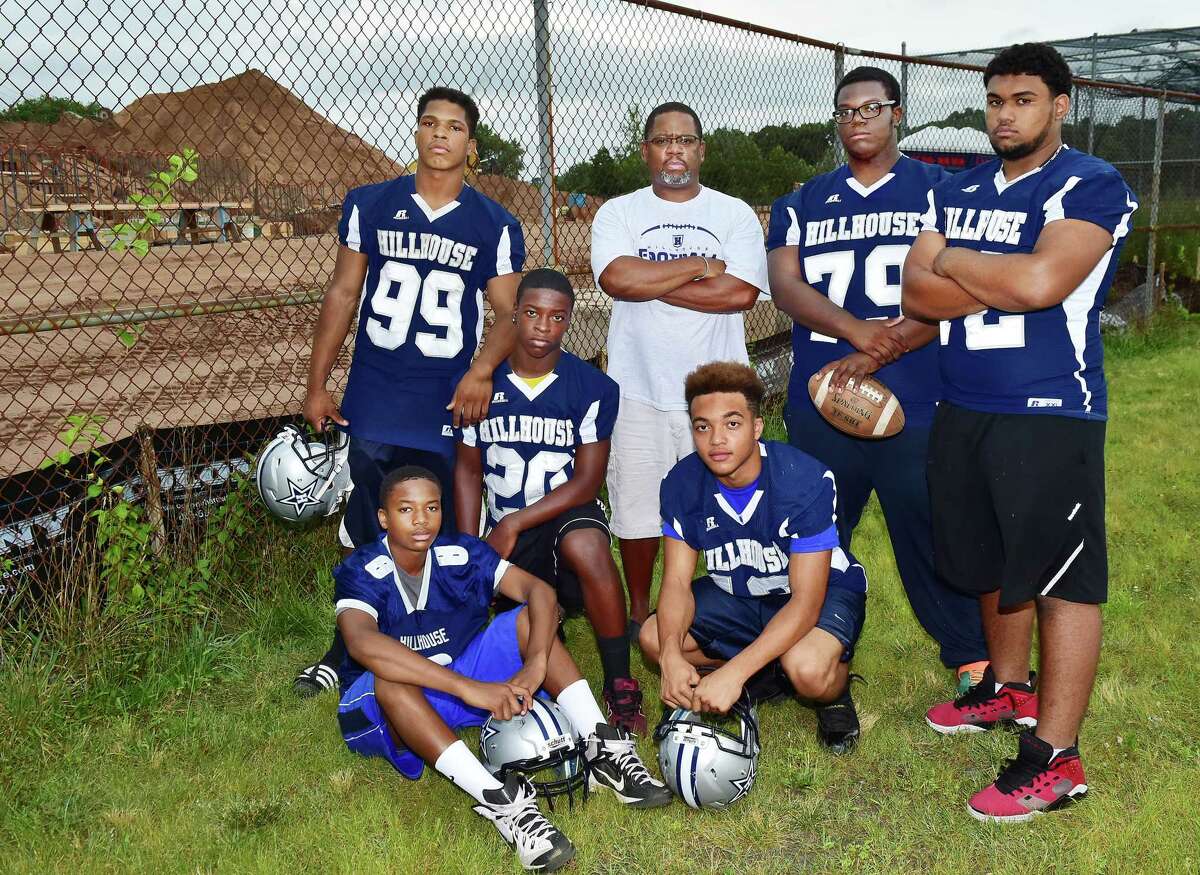 Members of the James Hillhouse football team, junior Damian Henderson (8), seated at left, sophomore Corey Pollard (20), kneeling, sophomore JT Gardner (13), senior André Wooten (99), Head coach Reggie Lytle, senior Noah Brown (79) and senior Fredrick Singh (72) are concerned Bowen Field will not be completed by the Elm City Classic in November as promised by the district. (Catherine Avalone – New Haven Register)