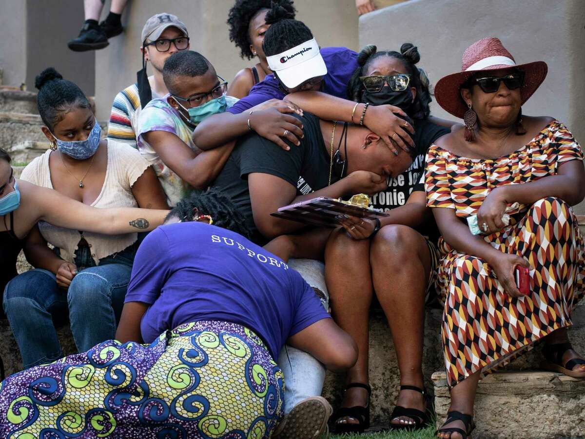 Antronie Scott Jr. center, cries during a memorial for his late father while his friends and family support him during an event put on to honor the families of victims of police violence in San Antonio, Tx., US, on Saturday, August 15, 2020. The event, ?’Healing Home,?“ was put on by Reliable Revolutionaries at La Villita and held remembrances for Marquise Jones, Charles Roundtree, Norman Cooper, Jesse Aguirre, Marcus McVea, and Antronie Scott alongside their families, friends, and supporters.