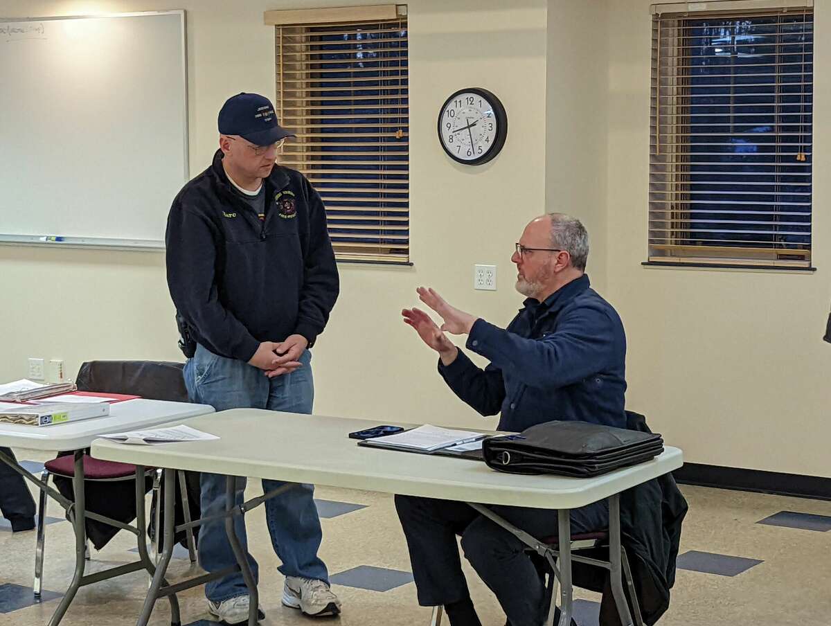Sanford Village Council member Marc Thrush, left, talks with Midland County Drain Commissioner Joe Sova during a Sanford special meeting Tuesday night at the Jerome Township Hall.