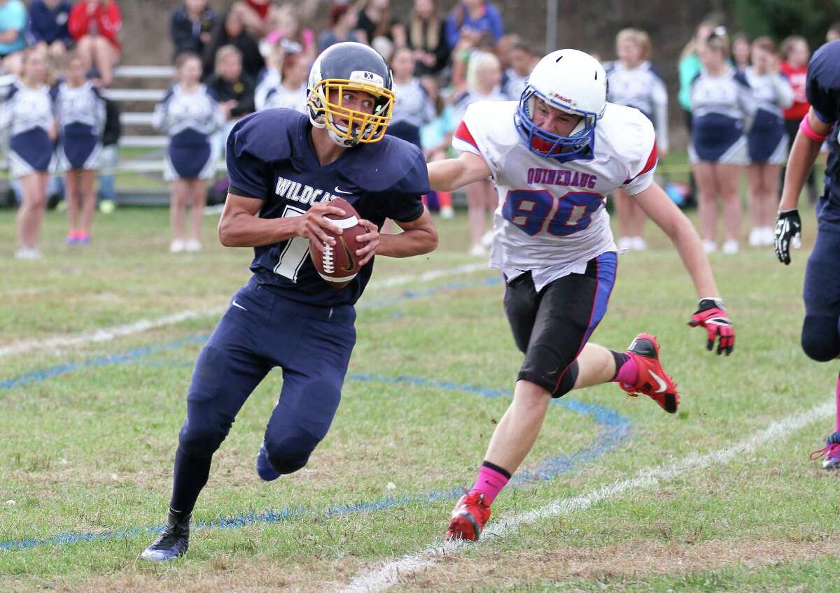 Graduated Wolcott Tech quarterback Mickey Ross runs for yardage as a Quinebaug defender gives chase during a game last season. Wolcott Tech is taking a break from varsity play in 2015 due to low numbers. (File photo Marianne Killackey)
