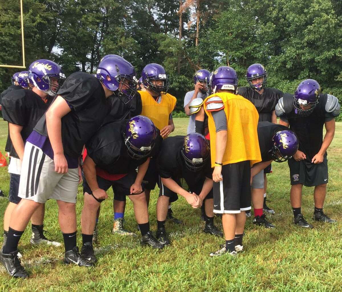 Ellington’s football team huddles up to run a play in practice earlier this preseason. The Knights, now without Somers, are hoping to make a return trip to the state playoffs, this time in Class S (Photo via Ellington football on Twitter)