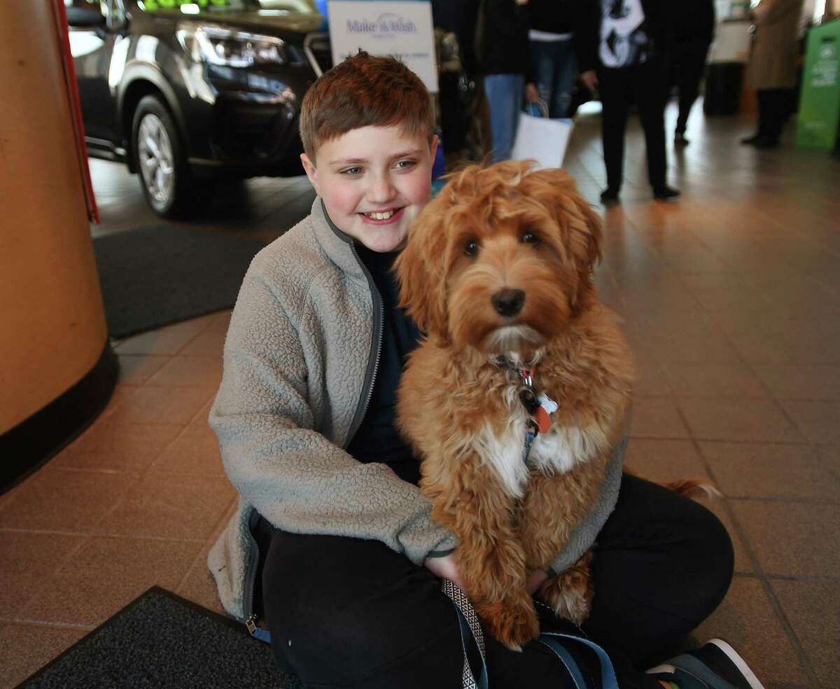 Luca Colangelo, 10, of Milford, with his new labradoodle puppy Champ, which he received through Make-A-Wish Connecticut, at Dan Perkins Subaru in Milford, Conn., on Wednesday, April 19, 2022. The dealership made a donation to Make-A-Wish this year of $47,825 dollars as part of Subaru's Share the Love Event.