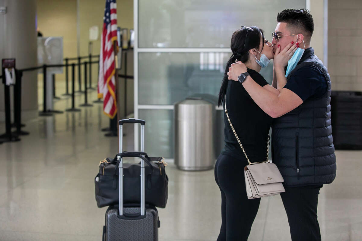 Gecel Gomez kisses Jaime Perez of San Antonio goodbye as she gets ready to depart home for California outside the TSA checkpoint in the San Antonio International Airport in San Antonio, Texas, on April 19, 2022.