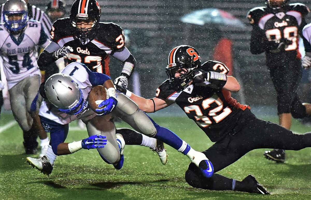 Shelton captain Alexander Kirk tackles West Haven sophomore Chris Chance as the Gaels defeat the Blue Devils, 40-20, in a Class LL state football quarterfinal game, Tuesday, December 1, 2015, at Finn Stadium at Shelton High School. (Catherine Avalone/New Haven Register)